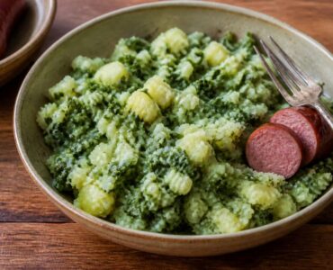Kom stamppot met gemengde aardappelpuree en groente, geserveerd op een houten tafel
