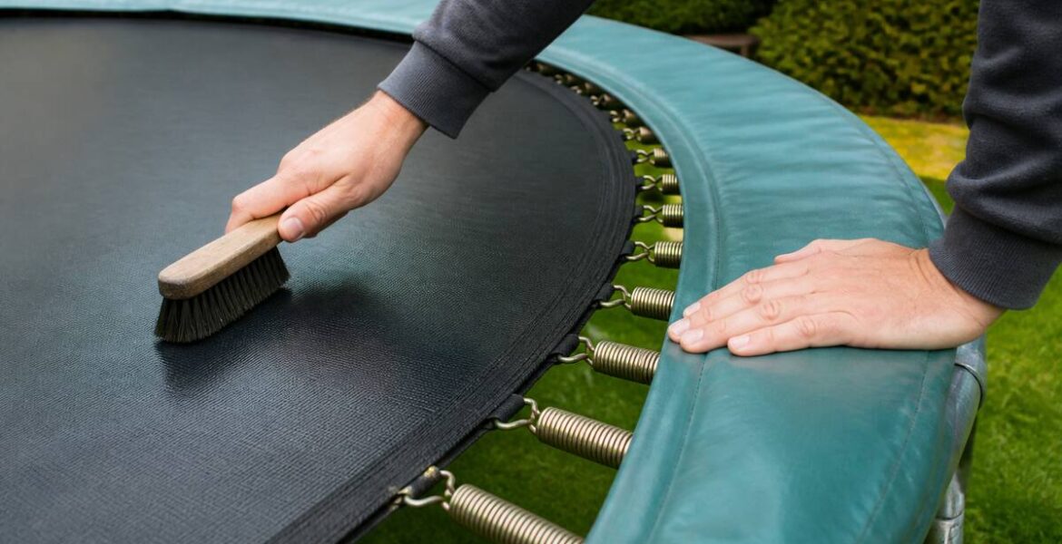 Iemand maakt een trampoline schoon en controleert het frame en de springmat